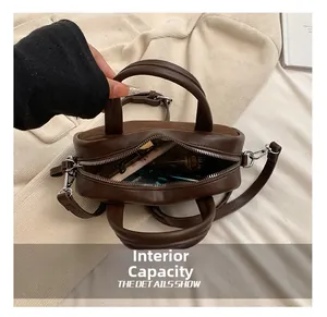 Interior capacity of the dark brown leather satchel bag showing cosmetics storage