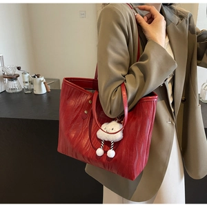 Détail d'un cabas rouge gaufré avec un charm nuage blanc dans le décor d'un café moderne