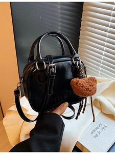 Retro black leather handbag with cute plush bear charm and embossed letter detail
