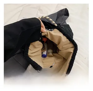 Detailed interior of large black quilted tote bag showing spacious storage with cosmetics