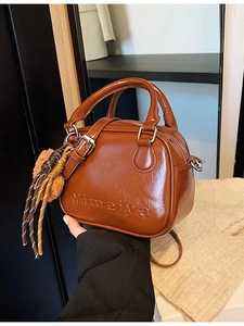Brown leather retro mini handbag with Yimeiya embossing and decorative tassel charm