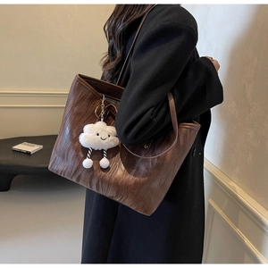 Sac cabas marron à texture bois avec breloque nuage porté par un mannequin