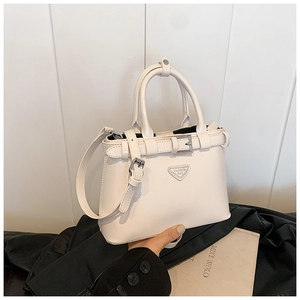Détail du sac à main en cuir PU crème avec plaque en métal et boucle décorative dorée