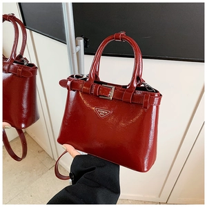 Détail du sac à main en cuir verni bordeaux avec boucles argentées et logo Fashion Bag