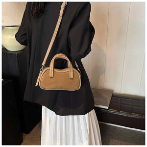 Detailed view of khaki leather and suede stitching on the handbag with logo details