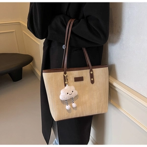 Détail du sac cabas texturé avec poignées en cuir et pendentif nuage amusant