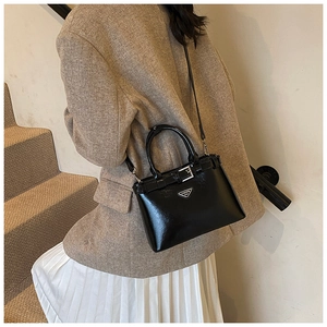 Sac à bandoulière chic en cuir brillant noir avec une tenue d'automne élégante