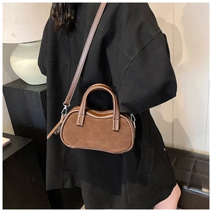 Brown frosted retro top-handle pillow bag with detachable strap shown on a model