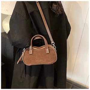 Detailed view of brown retro pillow bag with fashion text and matte leather texture