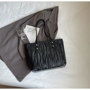 Détails de ce sac cabas noir avec texture ondulée et rivets dorés de qualité