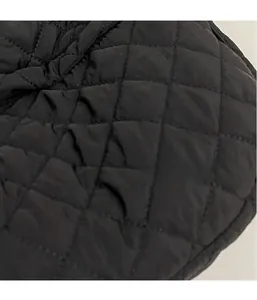 Vue macro du tissu matelassé noir à losanges montrant les détails légers