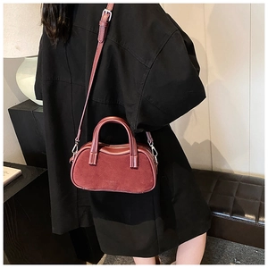 Close-up of deep red vintage pillow bag featuring matte texture and silver hardware details