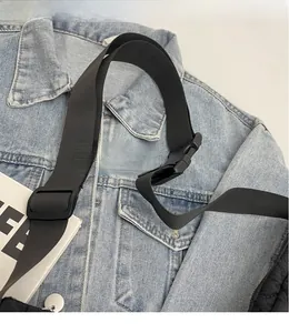 Détail de la bandoulière réglable en nylon noir avec boucle sur un sac à bandoulière