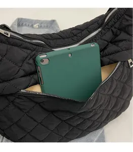 Détail du sac hobo matelassé noir montrant l'intérieur spacieux avec une tablette