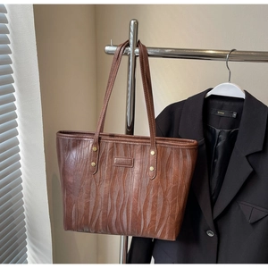 Vue détaillée du sac cabas marron avec texture gaufrée et rivets dorés élégants