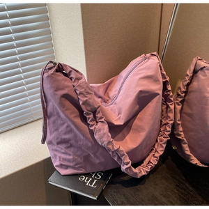 Detailed view of the purple nylon tote with a stylish scrunchie-style shoulder strap