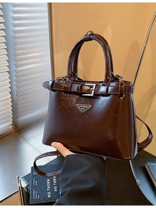 Sac bandoulière classique en cuir verni bordeaux avec un emblème triangulaire en métal