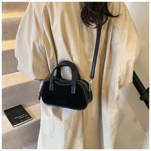 Detail of black suede and leather mixed handbag with top handle and fashion logo