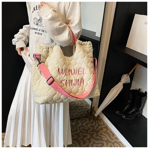 Quilted off-white tote bag detail with pink shoulder strap and drawstring closure design