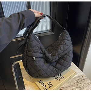 Détail du sac hobo noir matelassé avec surpiqûres en losange et bandoulière ajustable