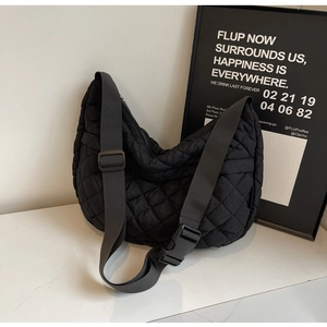 Détail du sac croissant matelassé noir avec boucle robuste et bandoulière en nylon
