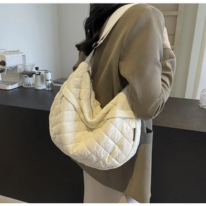 Détail du sac croissant en nylon matelassé beige avec motif en losanges et zip