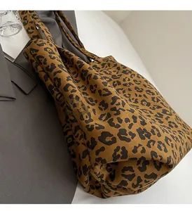 Détail du cabas en toile à motif léopard montrant la texture du tissu et les poignées