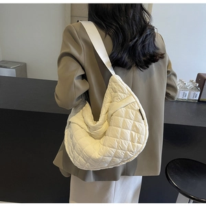 Détail du sac matelassé ivoire montrant la texture classique en losanges et la matière