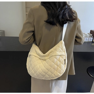 Vue détaillée des coutures matelassées et texture douce de ce sac demi-lune blanc cassé