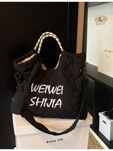 Black quilted tote bag with letter embroidery and woven rope handles for women