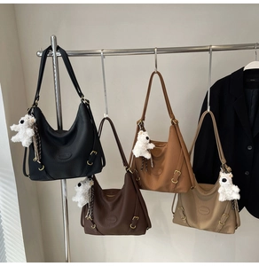 Row of large faux leather tote bags in four colors with cute plush dog pendants