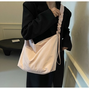 Detail view of pink canvas hobo shoulder bag featuring adjustable pleated drawstring straps
