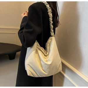 Detail of beige hobo bag with ruched cloud-style shoulder strap and soft fabric texture