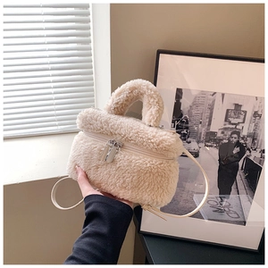 Detailweergave van beige pluchen emmertas van teddybont met dubbele rits en zacht handvat