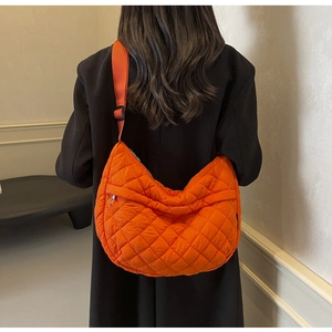 Détail du sac bandoulière matelassé orange en tissu rembourré avec motif à losanges