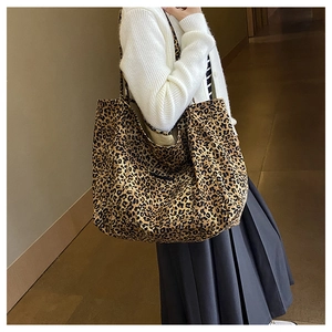 Detailed close-up of a large leopard print tote bag worn on shoulder for commuting