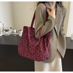 Sac fourre-tout en toile imprimé léopard rouge porté avec un blazer beige chic