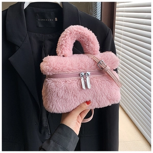 Detail van roze pluizige bucketbag met ritssluiting en een handvat aan de bovenkant
