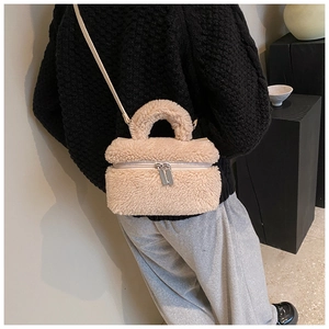 Detailweergave van een crème pluche crossbodytas van imitatiebont bij de outfit