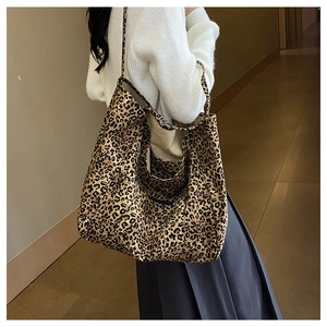 Detailed close-up of a large leopard print tote bag worn on a woman's shoulder
