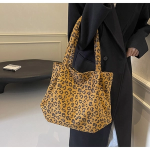 Sac fourre-tout tendance à motif léopard porté par un mannequin en manteau noir