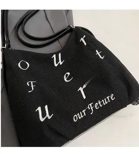 Detailed macro view of black ribbed tote bag fabric with white Future letter embroidery