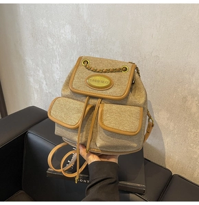 Détail du mini sac à dos en toile kaki avec bordure en cuir marron et boucles dorées