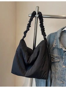 Minimalist black hobo shoulder bag with a stylish ruched strap and zipper closure