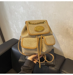 Détail du sac à dos en toile kaki avec garniture en cuir et poignée en chaîne dorée