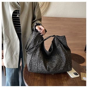 Detail of a leopard print canvas tote bag with functional outer pocket and large interior
