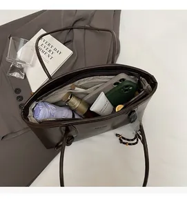 Spacious interior of dark brown tote bag showing umbrella, phone and cosmetics storage