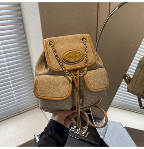 Détail d'un mini sac à dos en toile avec chaîne et petites poches avant à rabat