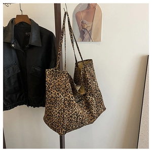 Leopard print tote bag hanging next to black leather jacket in a stylish setting