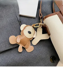 Detail von Leder-Affenanhänger und Y-Buchstabenanhänger an einer schicken Handtasche